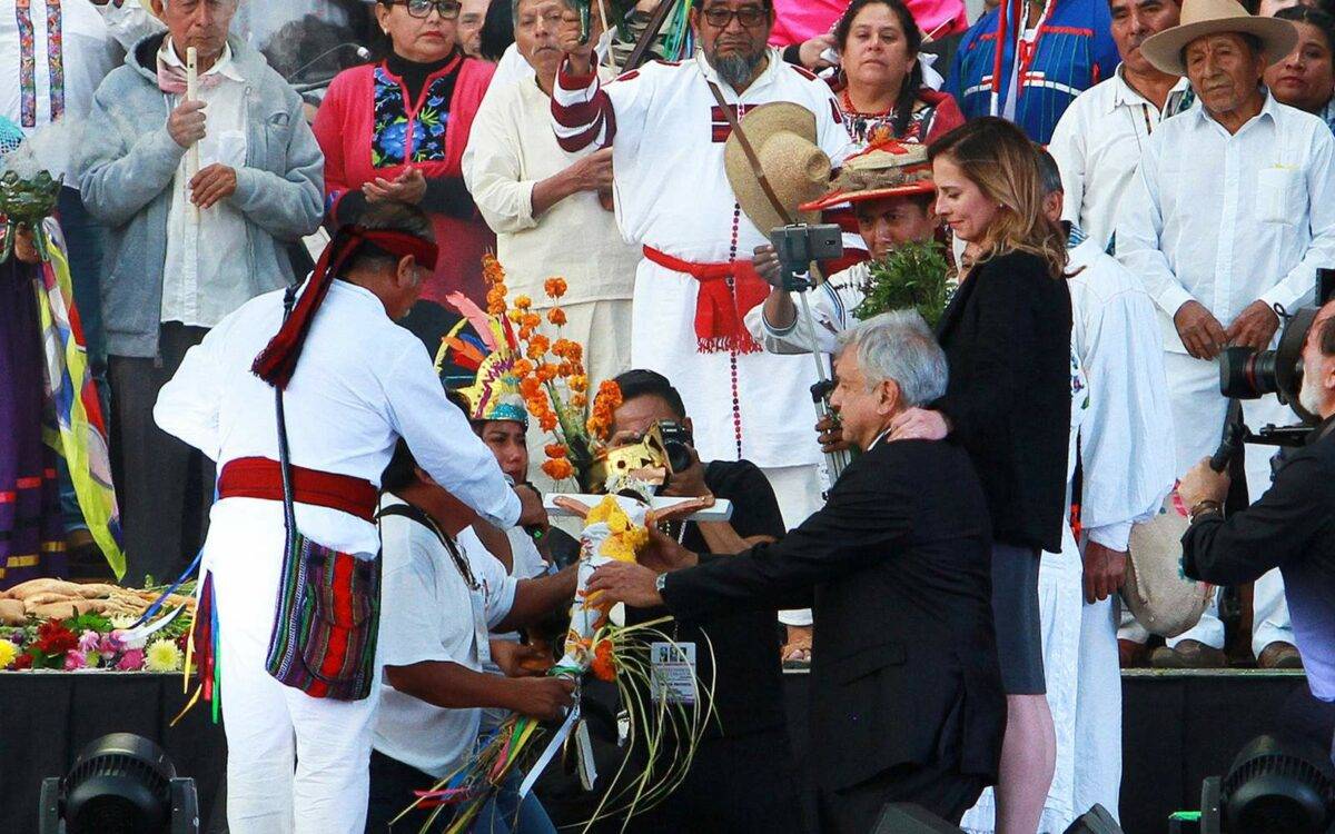 El presidente López Obrador arrodillado ante brujo durante ceremonia en el Zócalo.