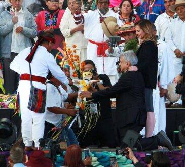 El presidente López Obrador arrodillado ante brujo durante ceremonia en el Zócalo.