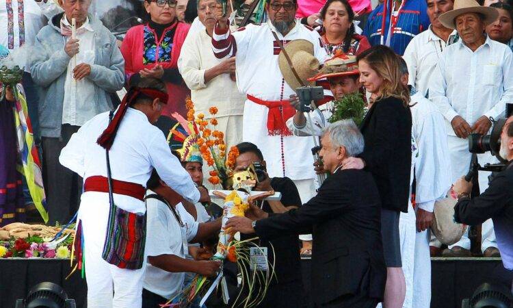 El presidente López Obrador arrodillado ante brujo durante ceremonia en el Zócalo.